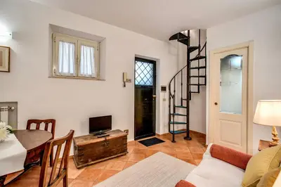a living room with a table and a tv and a staircase at Charlotte Luxury Home Coronari in Rome