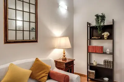 a living room with a couch and a lamp at Charlotte Luxury Home Coronari in Rome