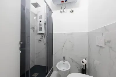 a white bathroom with a toilet and a shower at San Paolo Suites Metro Station in Rome