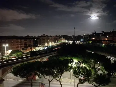 a view of a city at night with a moon at VATICAN GUEST HOUSE ROOMS in Rome in Rome