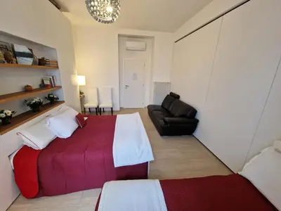 a bedroom with a red and white bed and a couch at VATICAN GUEST HOUSE ROOMS in Rome in Rome