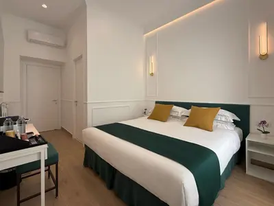 a bedroom with a large bed with a green headboard at Nova Luxe in Rome