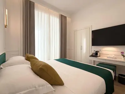 a hotel room with two beds and a television at Nova Luxe in Rome