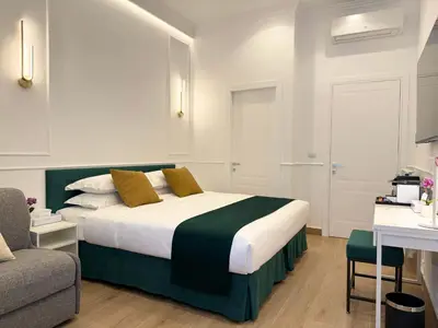a bedroom with a bed with a green and white comforter at Nova Luxe in Rome