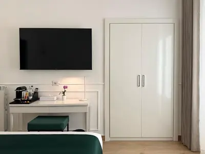 a bedroom with a desk and a tv on a wall at Nova Luxe in Rome