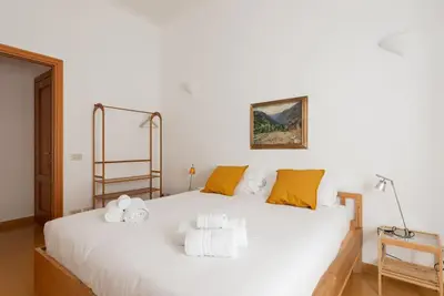 a bedroom with a large white bed with yellow pillows at Colosseum Number sixteen apartment in Rome