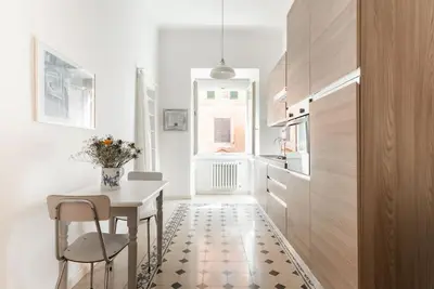 a dining room with a table and chairs and a kitchen at Colosseum Number sixteen apartment in Rome