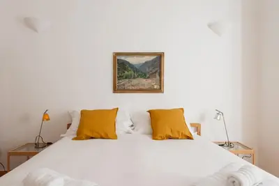 a bedroom with a white bed with yellow pillows at Colosseum Number sixteen apartment in Rome