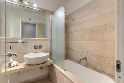 a bathroom with a sink and a tub and a mirror at Ciancaleoni Gruppo M&L Apartments in Rome