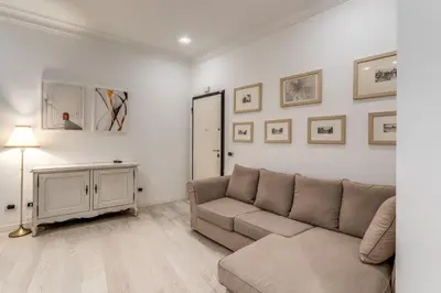 a living room with a couch and pictures on the wall at Ciancaleoni Gruppo M&L Apartments in Rome