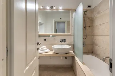 a bathroom with a sink and a tub and a mirror at Ciancaleoni Gruppo M&L Apartments in Rome