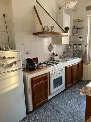 a kitchen with a stove and a white refrigerator at Silvia's Home in Rome
