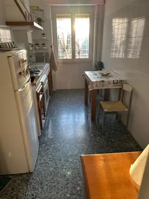 a kitchen with a refrigerator and a table in it at Silvia's Home in Rome