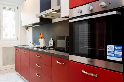 a kitchen with red cabinets and a microwave at Romantic Malatesta in Rome