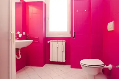 a pink bathroom with a toilet and a sink at Romantic Malatesta in Rome