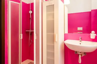 a pink bathroom with a sink and a mirror at Romantic Malatesta in Rome