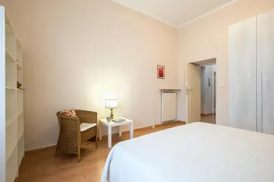 a bedroom with a bed and a chair and a table at Vatican Museums Cozy Apartment in Rome