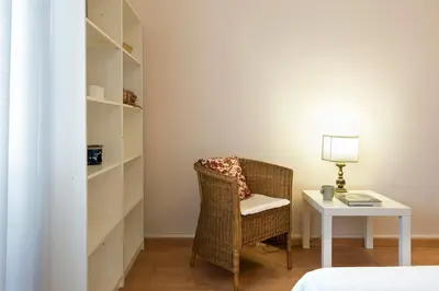 a room with a chair and a table with a lamp at Vatican Museums Cozy Apartment in Rome