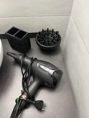 a blow dryer sitting on the floor next to a bowl at HOME Sweet Home Vatican City in Rome