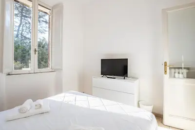 a white bedroom with a bed and a tv at LA DOLCE VITA - stone's throw from the city center in Rome