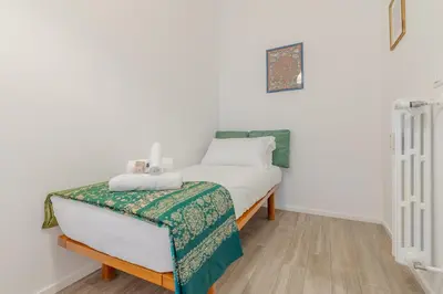 a bedroom with a bed with a green and white blanket at Journalist Apartment Sistine Chapel in Rome