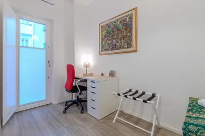 a bedroom with a desk and a red chair at Journalist Apartment Sistine Chapel in Rome