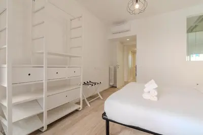 a white bedroom with a bed and a mirror at Journalist Apartment Sistine Chapel in Rome