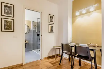 a dining room with a table and chairs and a shower at Palazzo Sapienza Design Suites in Rome