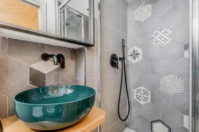 a bathroom with a green sink and a shower at Palazzo Sapienza Design Suites in Rome