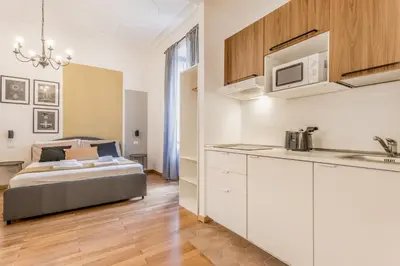 a kitchen and living room with a bed in a room at Palazzo Sapienza Design Suites in Rome