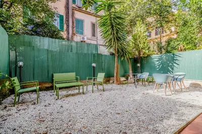 a group of chairs and tables in front of a fence at Palazzo Sapienza Design Suites in Rome