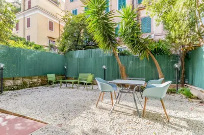 a patio with chairs and a table and a fence at Palazzo Sapienza Design Suites in Rome