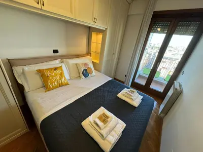 a bedroom with a large bed with towels on it at Nice View in Ostiense with balcony in Rome