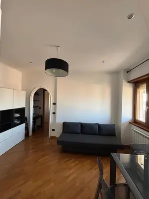 a living room with a couch and a table at Nice View in Ostiense with balcony in Rome