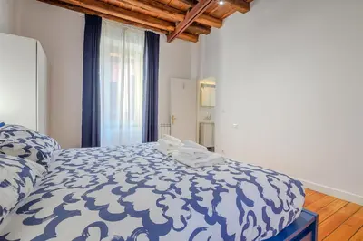 a bedroom with a bed with a blue and white comforter at Cozy Flat Orso Navona square in Rome