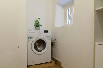 a laundry room with a washing machine in a white wall at Cozy Flat Orso Navona square in Rome