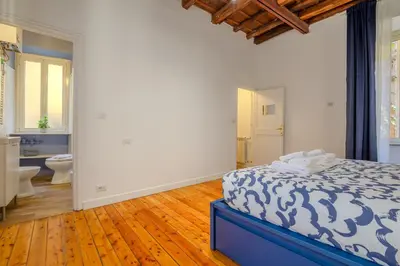 a bedroom with a blue and white bed and a bathroom at Cozy Flat Orso Navona square in Rome