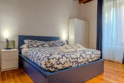 a bed with a blue headboard in a bedroom at Cozy Flat Orso Navona square in Rome