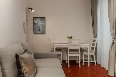a living room with a couch and a table and chairs at Cozy Flat Orso Navona square in Rome