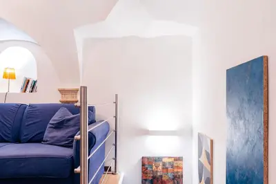 a living room with a blue couch and a mirror at Restart Accommodations Lante in Rome