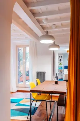 a dining room with a wooden table and yellow chairs at Restart Accommodations Lante in Rome