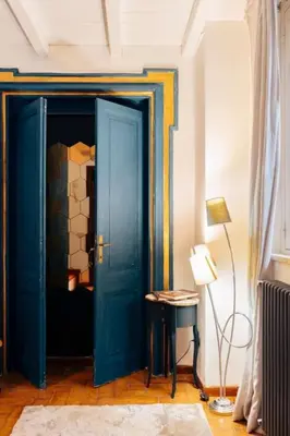 a blue door in a room with a table and a lamp at Restart Accommodations Lante in Rome