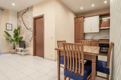 a kitchen with a wooden table and wooden chairs at Borgo Vittorio 76 in Rome