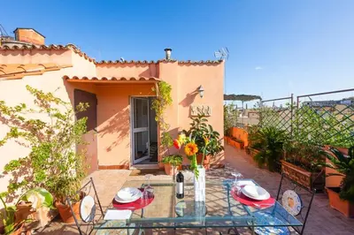 a patio with a glass table with flowers on it at Centro Piccolo attico da sogno in Rome