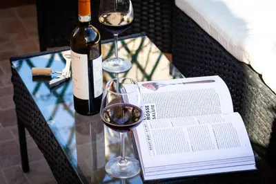 a glass table with two glasses of wine and a book at Centro Piccolo attico da sogno in Rome