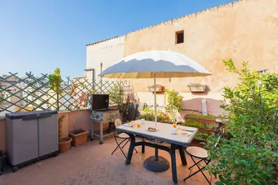 a patio with a table and an umbrella at Centro Piccolo attico da sogno in Rome