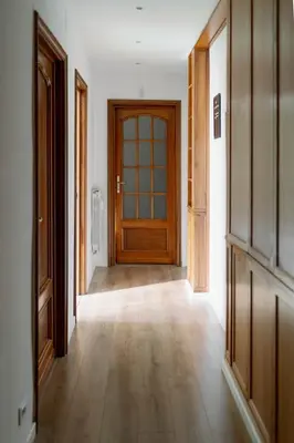 an empty hallway with a wooden door and wooden floors at La Dolce Vita rooms in Rome