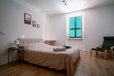 a bedroom with a bed and a chair and a window at La Dolce Vita rooms in Rome