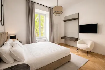 a white bedroom with a large bed and a chair at Vatican Boutique - 1 bedroom Apartment - Bilocale in Rome