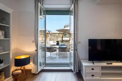 a living room with a sliding glass door to a balcony at AndreaSuite Gianicolo in Rome